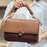 Sac à main avec anse en corde nouée et fermeture métallique.