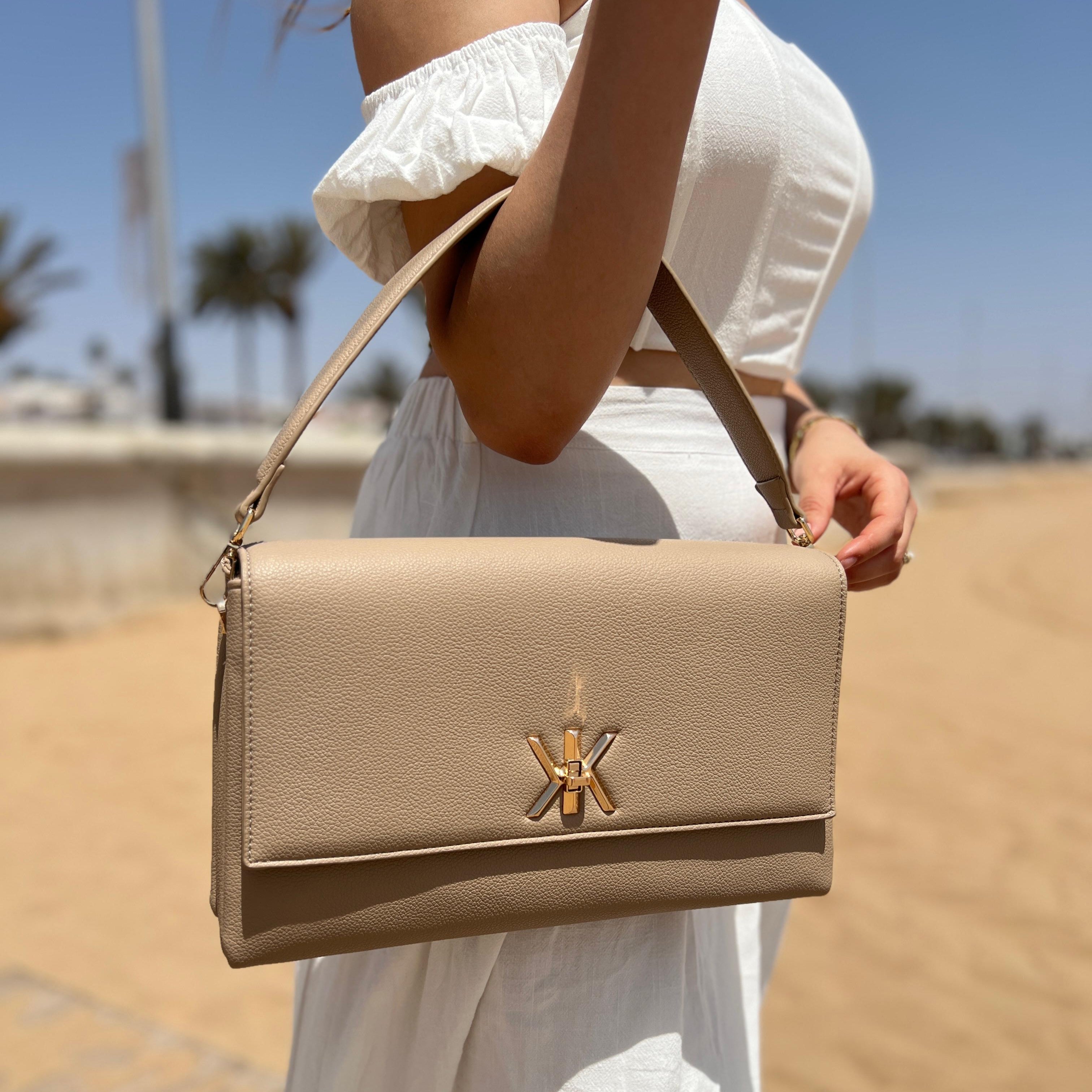 Pochette noire avec anse et bandoulière décorée de détails dorés