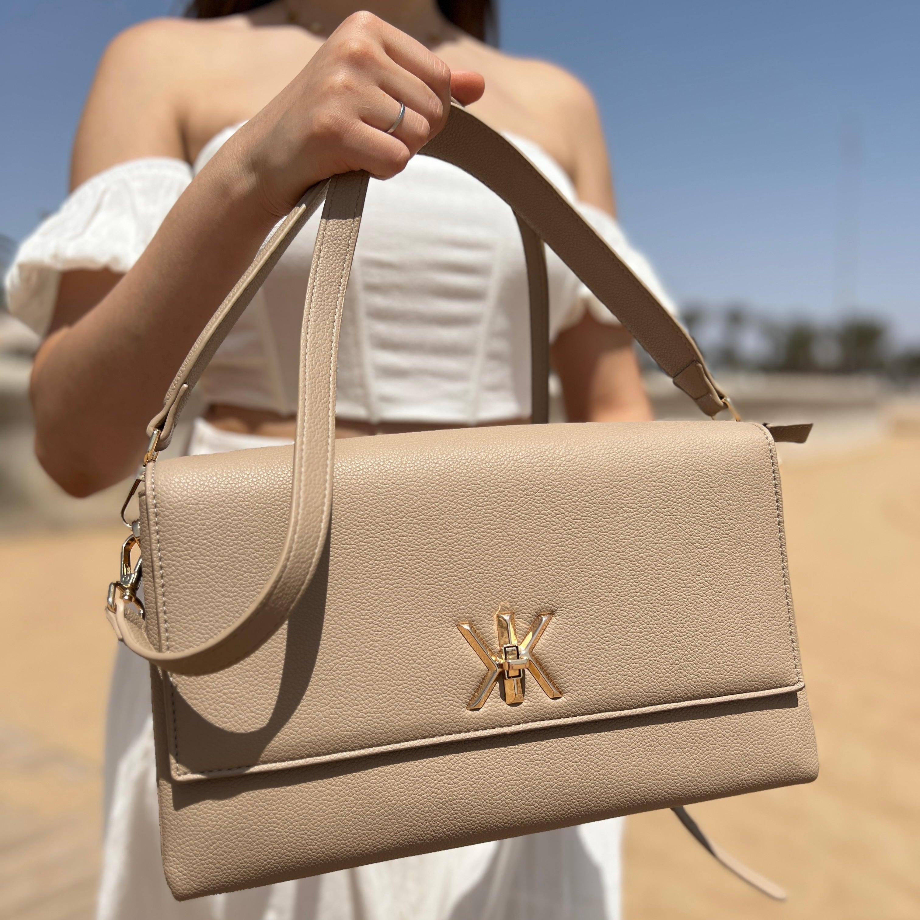 Pochette noire avec anse et bandoulière décorée de détails dorés