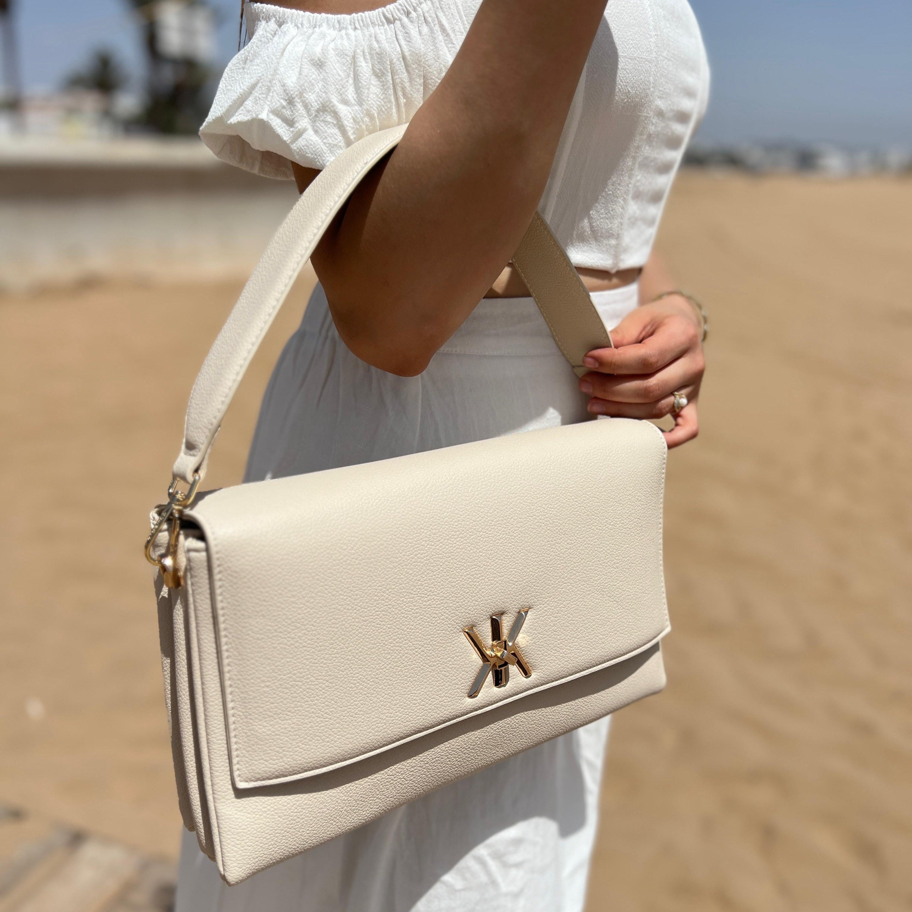 Pochette noire avec anse et bandoulière décorée de détails dorés