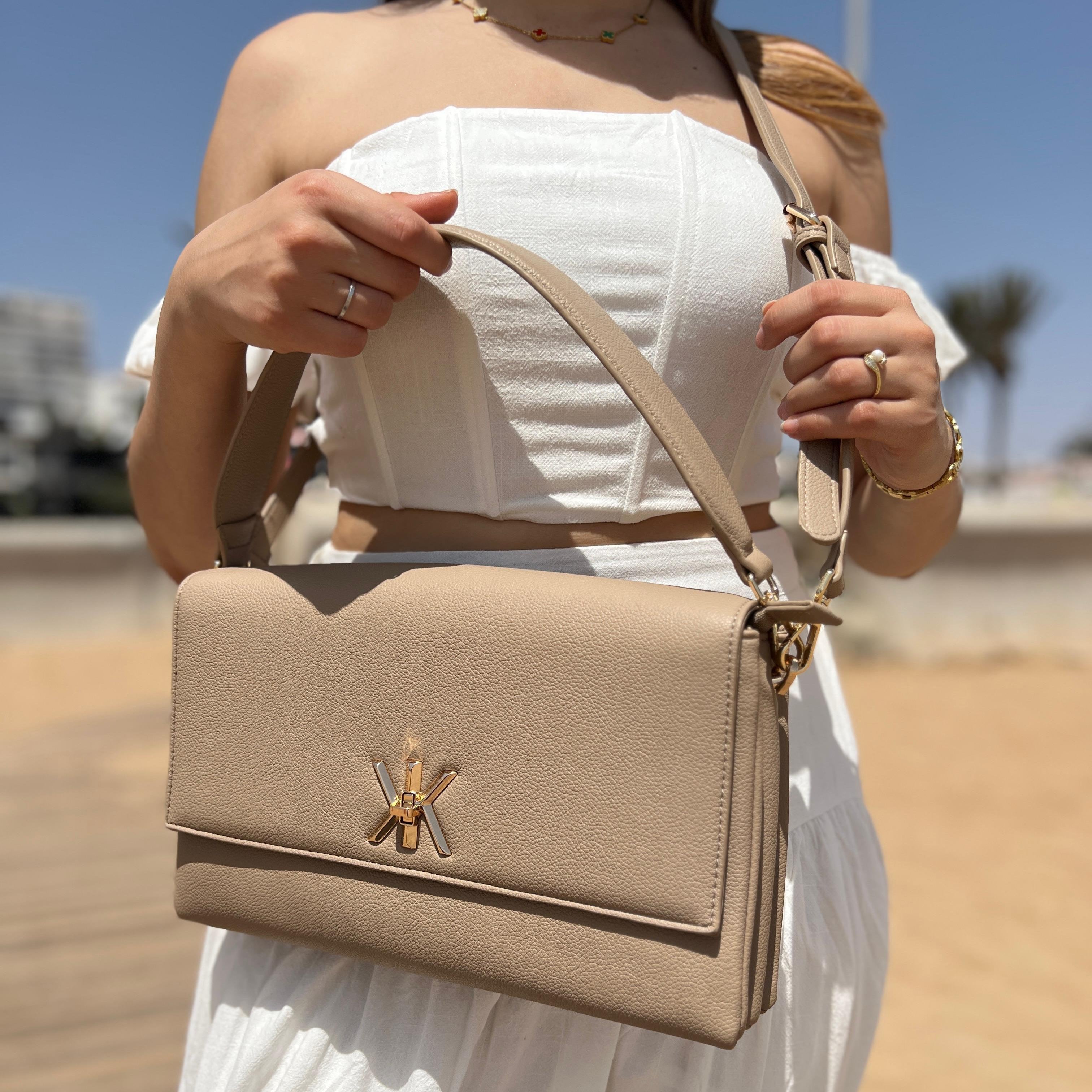 Pochette noire avec anse et bandoulière décorée de détails dorés