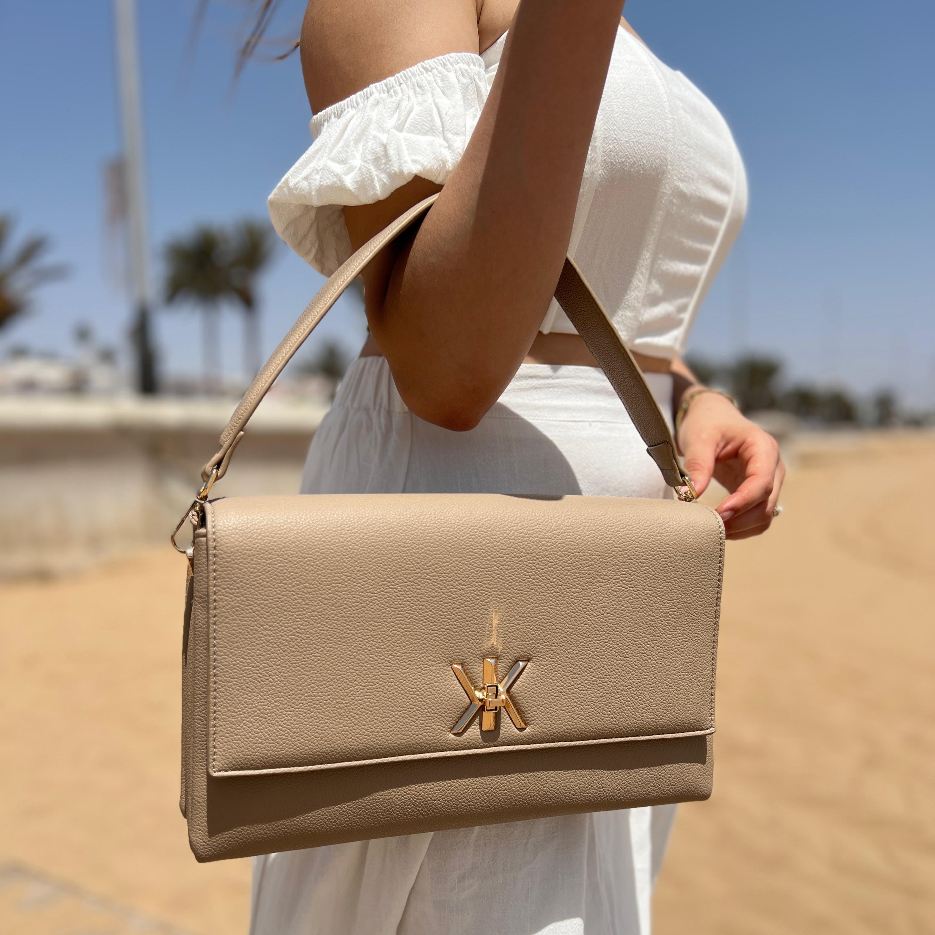 Pochette noire avec anse et bandoulière décorée de détails dorés