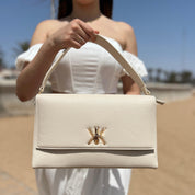 Pochette noire avec anse et bandoulière décorée de détails dorés