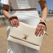 Pochette noire avec anse et bandoulière décorée de détails dorés