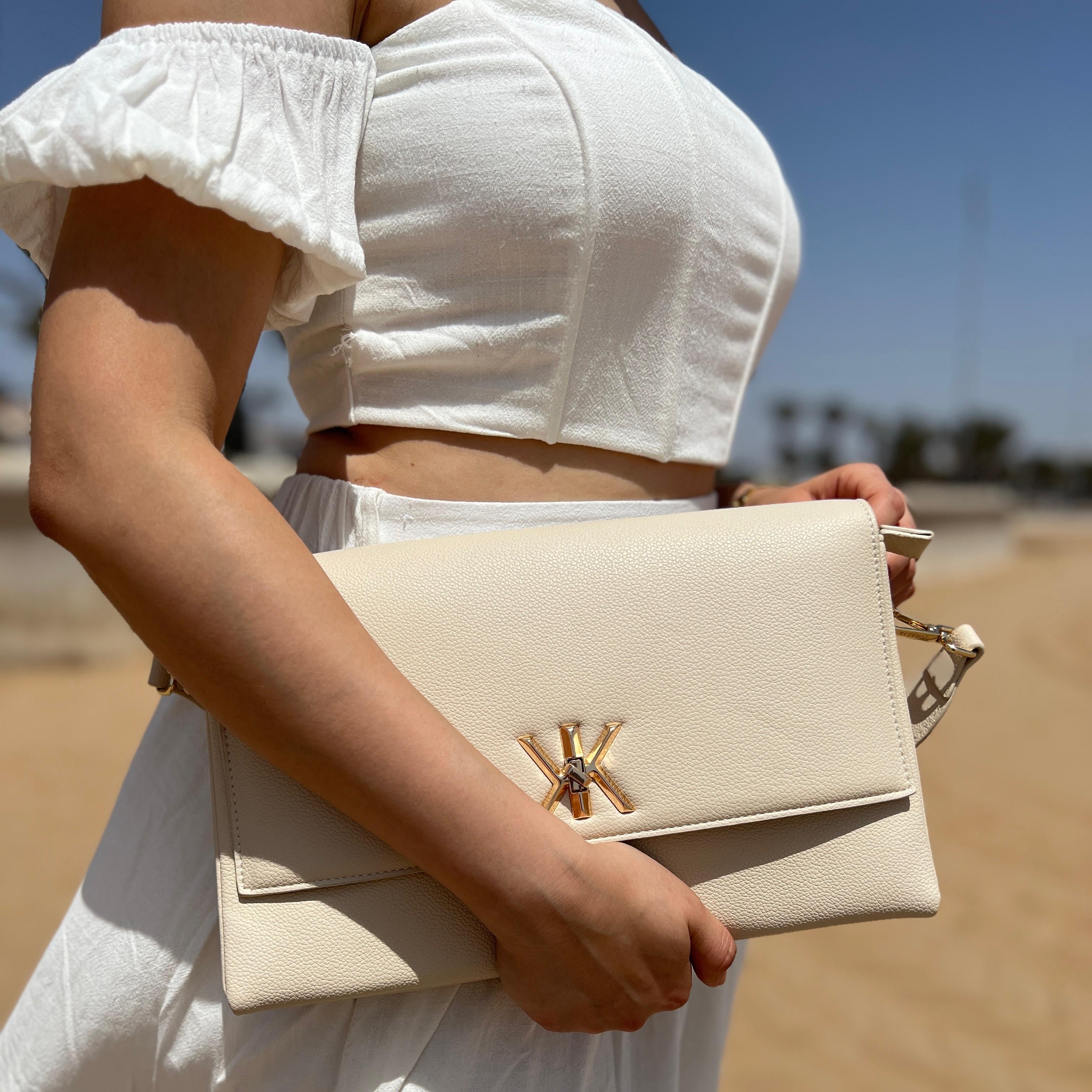 Pochette noire avec anse et bandoulière décorée de détails dorés
