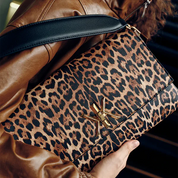 Pochette noire avec anse et bandoulière décorée de détails dorés