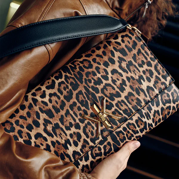 Pochette noire avec anse et bandoulière décorée de détails dorés