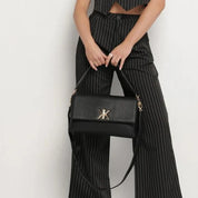 Pochette noire avec anse et bandoulière décorée de détails dorés